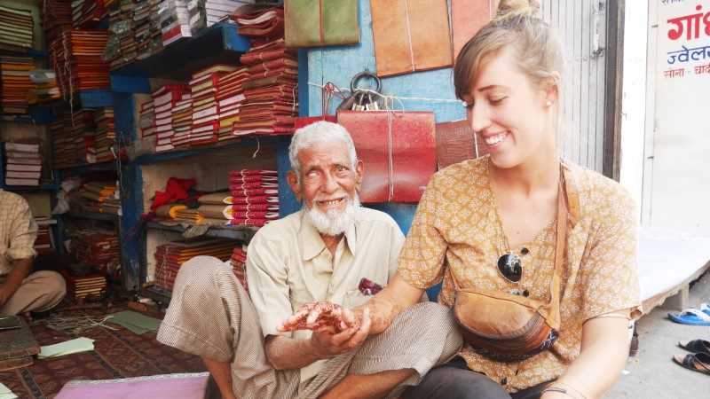 A traveller sits with an Indian man