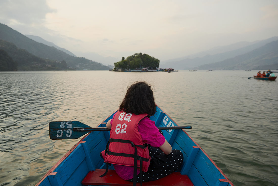 Intrepid traveller on a rowboatenture onto Phewa Lake in Pokhara, Nepal