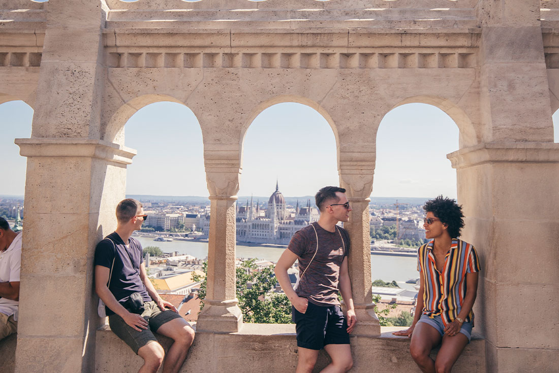 Travellers sit in archways that look out over Budapest 