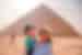 Mother and daughter smile together in front of one of the Great Pyramids of Giza in Cairo