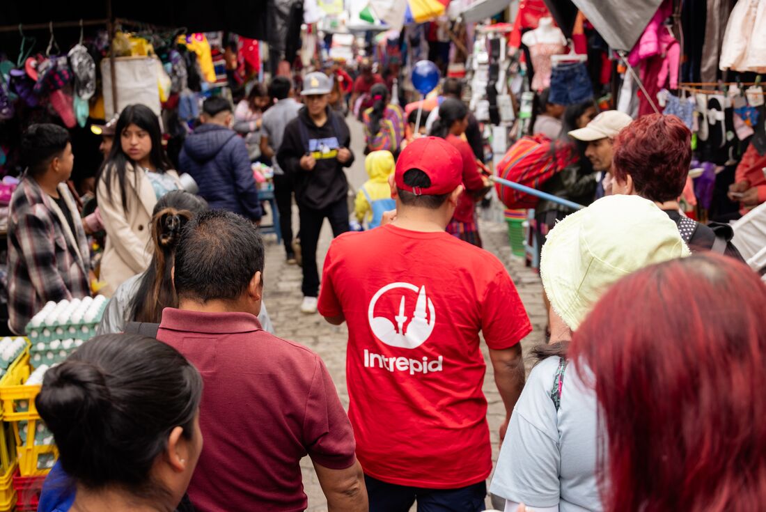 Back POV of leader walking with travellers through Chichicastenango Market Im Guatemala