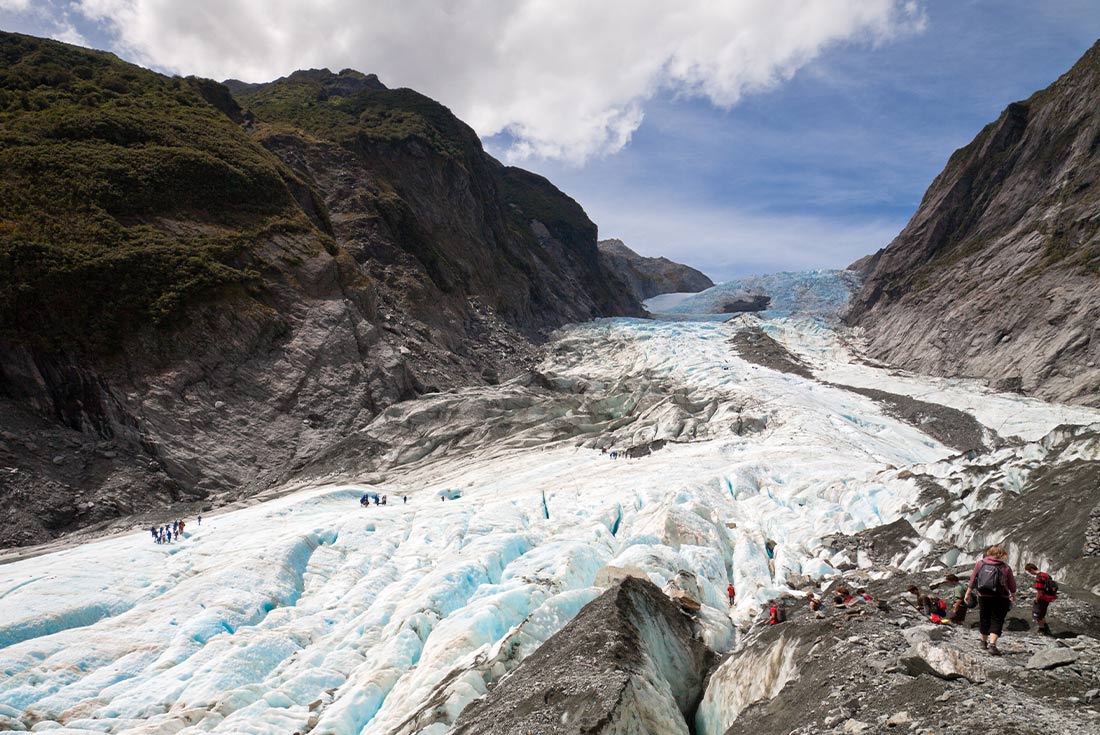 Tourists hiking Franz Josef Glacier in New Zealand