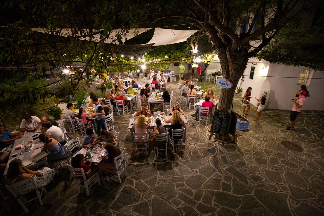 High shot of a Folegandros island cafe at night with travellers and locals having dinner