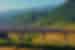 Bullet train on high rail line passing through the mountain backed agricultural landscape of Yunnan Province China
