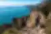 POV of traveller hiking high in the mountains in Praiano, Positano, Italy, looking out to the blue ocean and blue sky horizon