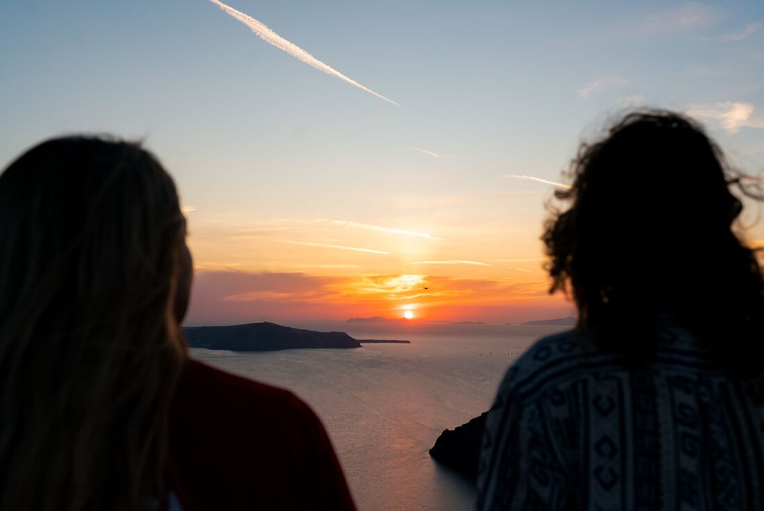 Intrepid travellers watching the sunset in Santorini