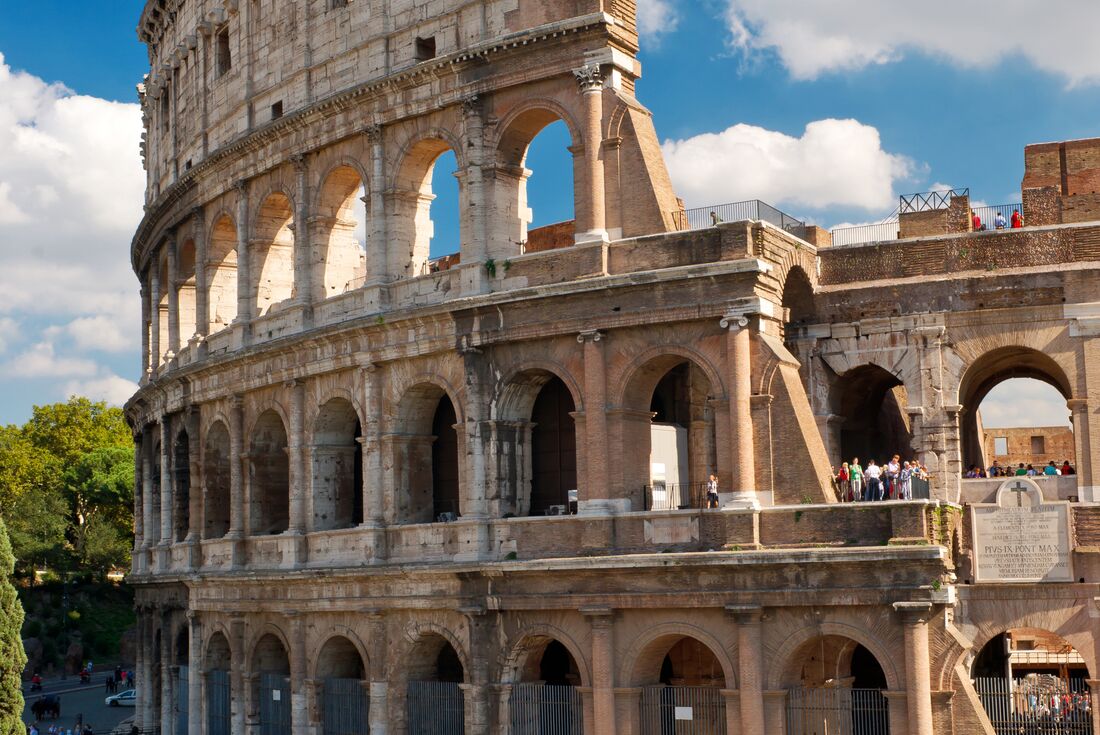Vertical image of side facade of the Colosseum in Rome, Italy on a blue sky day.