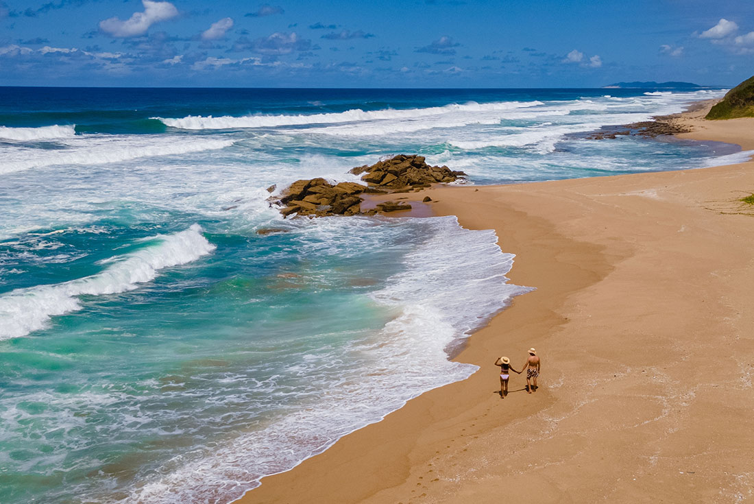 Drone shot of couple walking along Cape Vidal Beach, South Africa