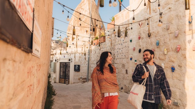 Two travellers walk along a street in Cappadocia, Turkey.