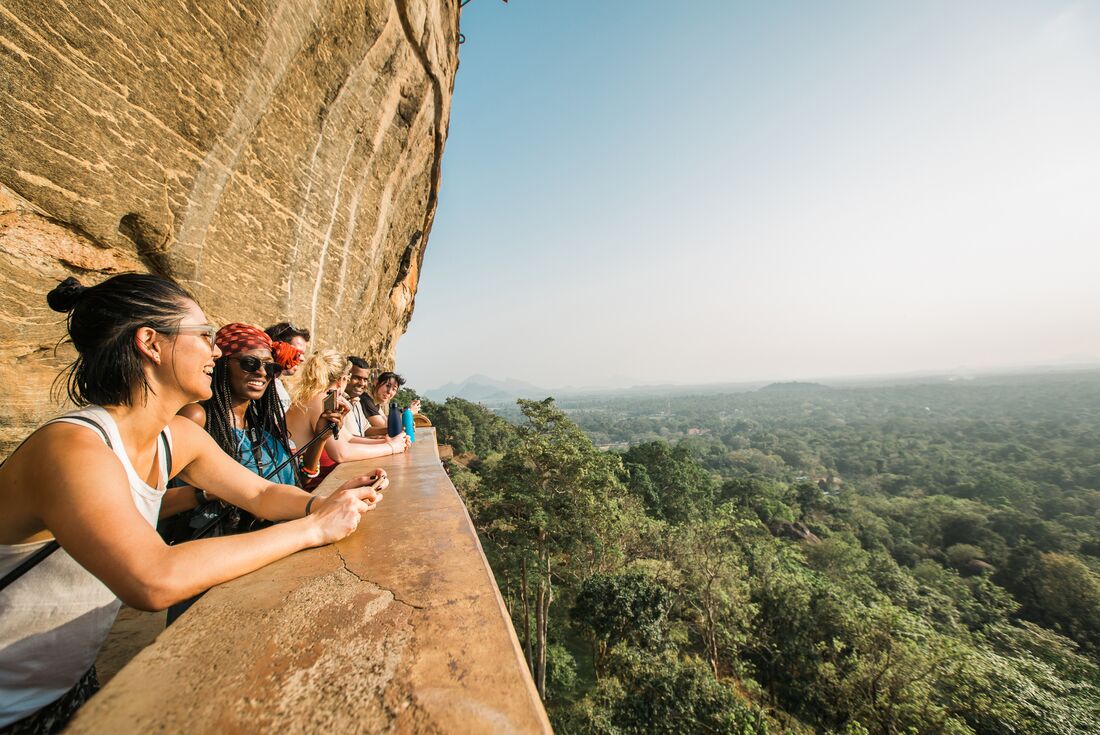 Group of travellers looking out on landscape from a scenic viewpoint on Sigiriya in Sri Lanka during an Intrepid Travel tour.