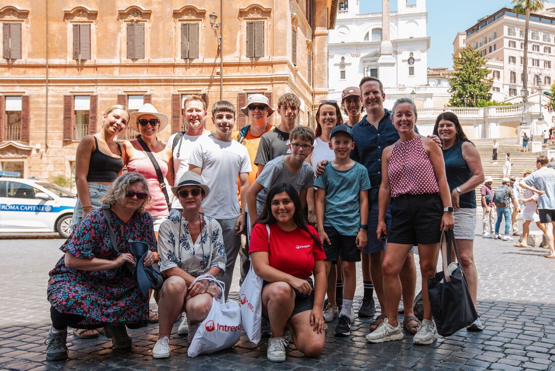 Group of family travellersa and leader pose for a group shot in the sunny streets of Rome Italy
