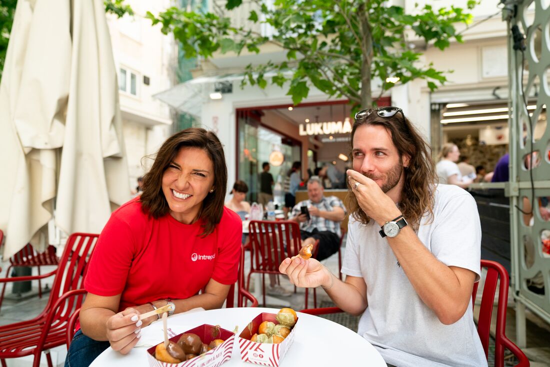 Intrepid leader and traveller tasting Greek pastry 