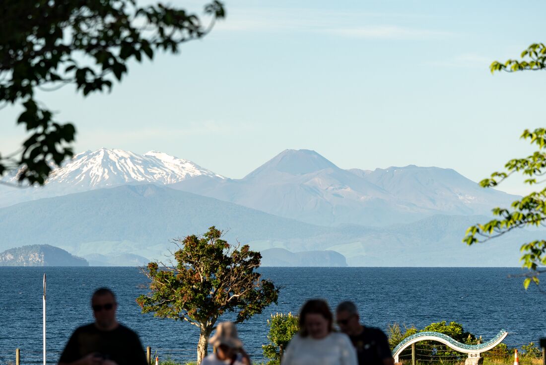 View of Mount Tongariro with a lake and travellers in the foreground, New Zealand