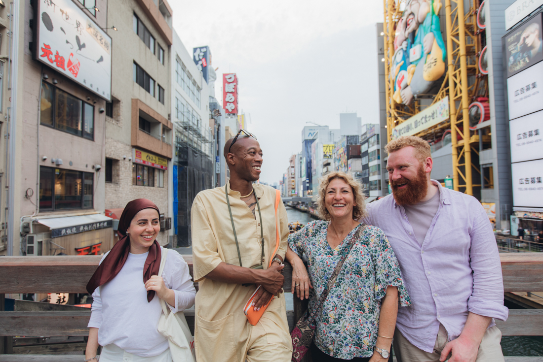 Intrepid travellers stop on a bridge to take a break from exploring in Osaka