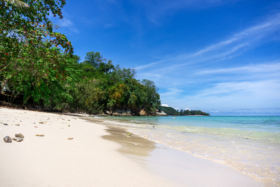 Crystal clear ocean water rolls onto Manukan Island beach off the coast of Borneo