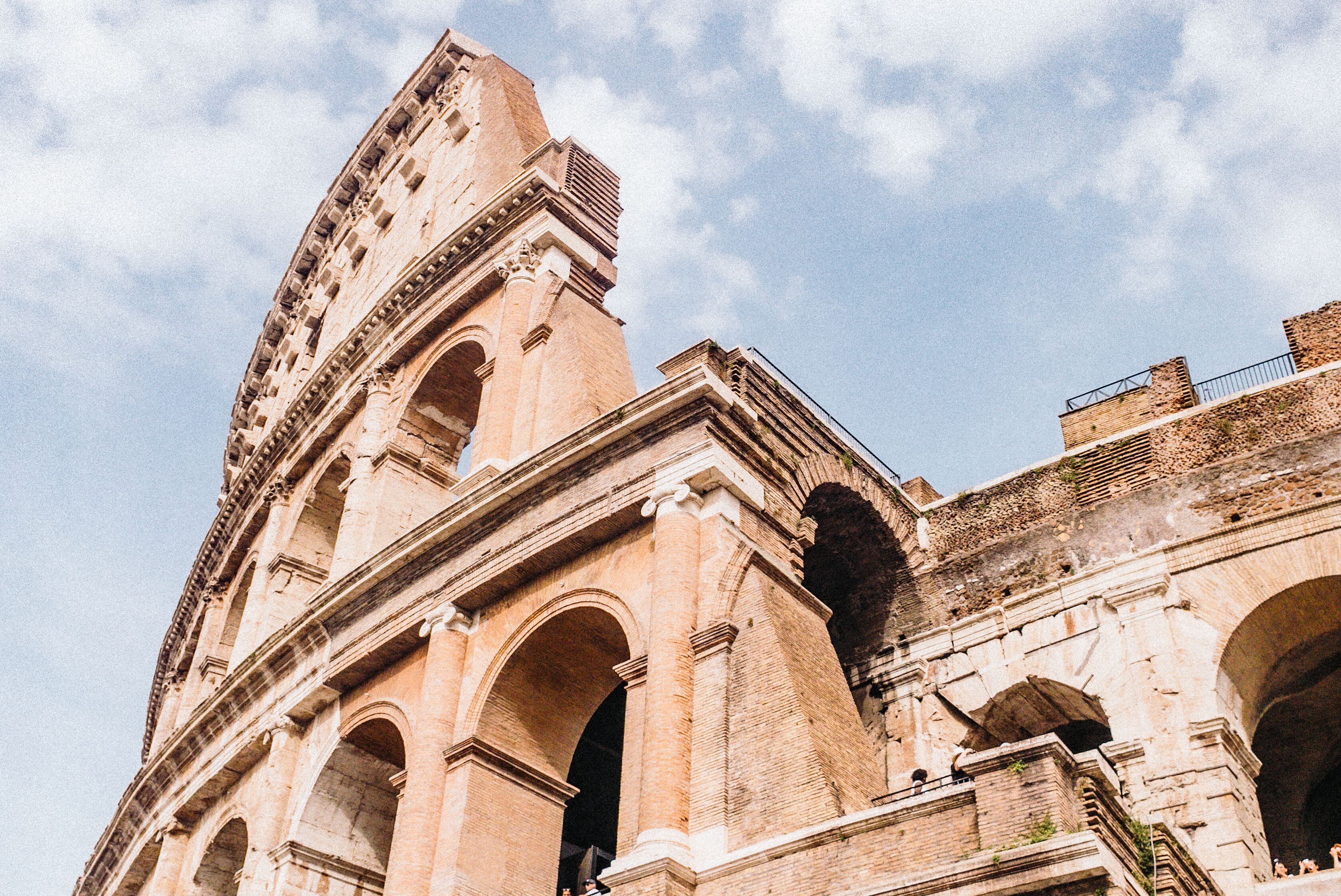 Looking up at the architecture of the Colosseum in Rome, the capital of Italy with a sky backdrop