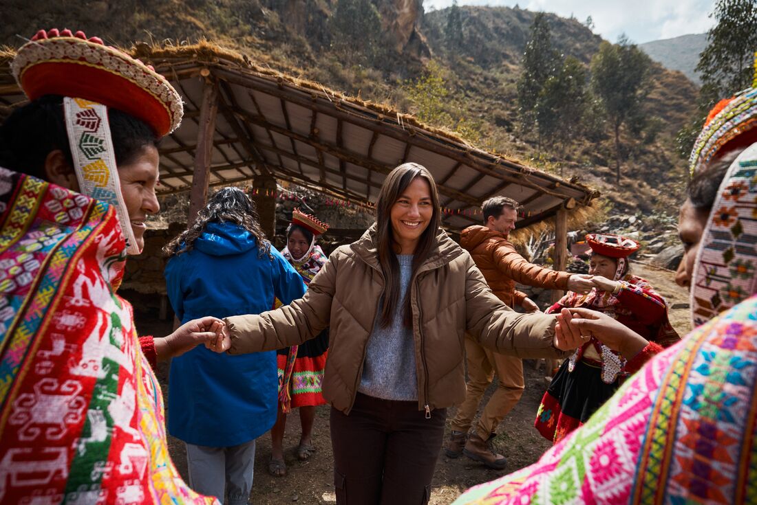 Young Intrepid traveller smiles while dancing with locals of the Huilloc community in the Sacred Valley