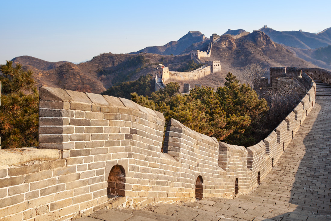 The wonder of The Great Wall of China trails off into the distance over mountain peaks