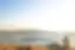 Traveller perched on a high hill looks out over the sparkling Aegean and the island of Mykonos