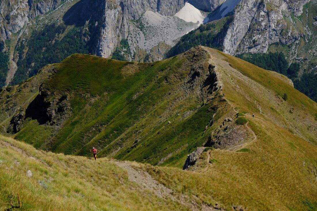Traveller with hiking sticks goes up the Volusnica loop trail in Albania's Prokletije National Park