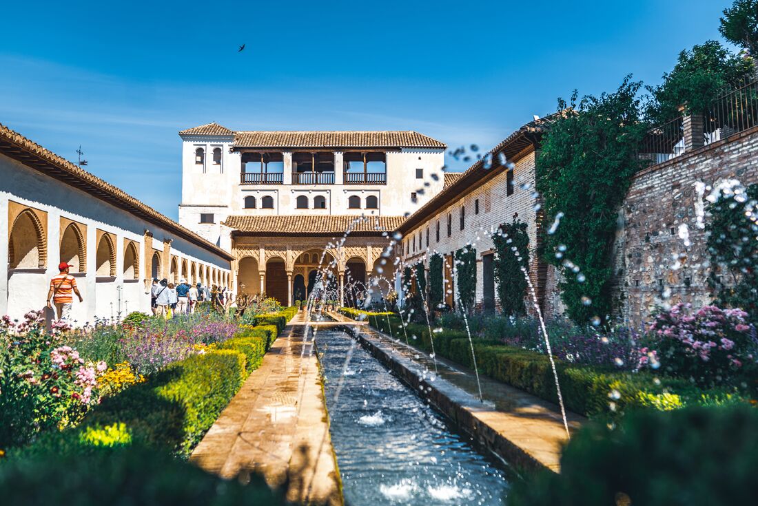 Alhambra Palace interior with running fountains in a gently curated garden outside Granada, Spain