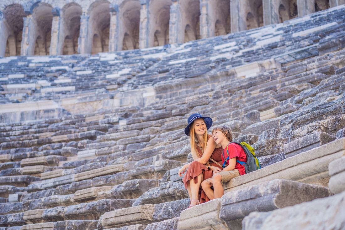 Mother and son relax on the stione seats of an ancient ampitheater in Antalya