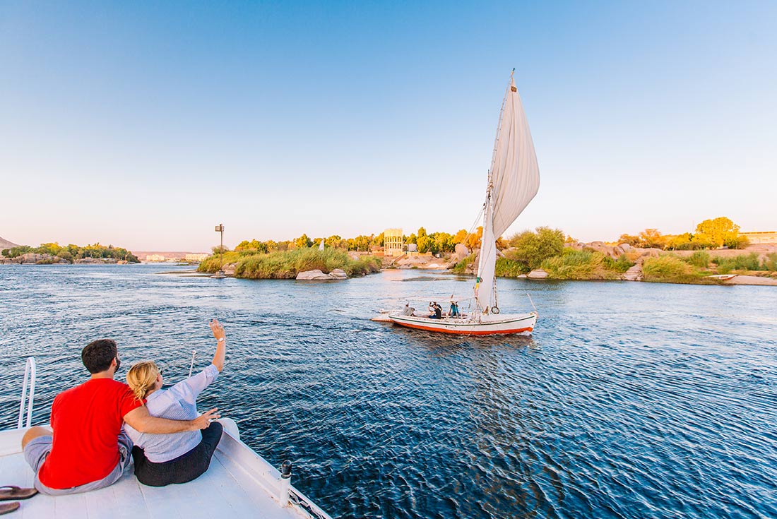 XEPN - Couple waving at passengers on another boat across the Nile river