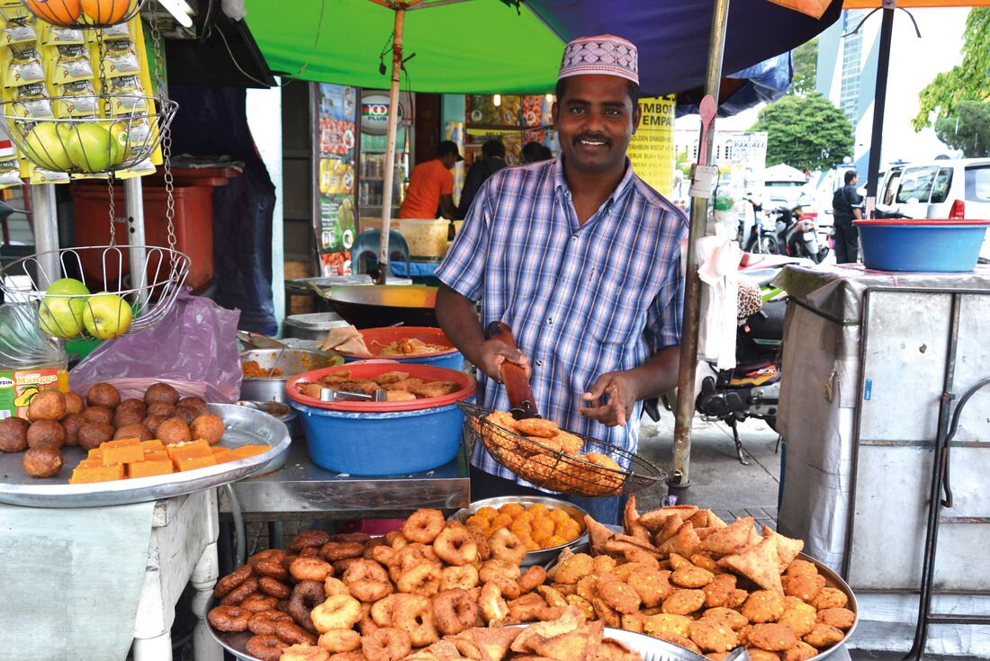 Street food vendor showing off fried snacks in Malaysia
