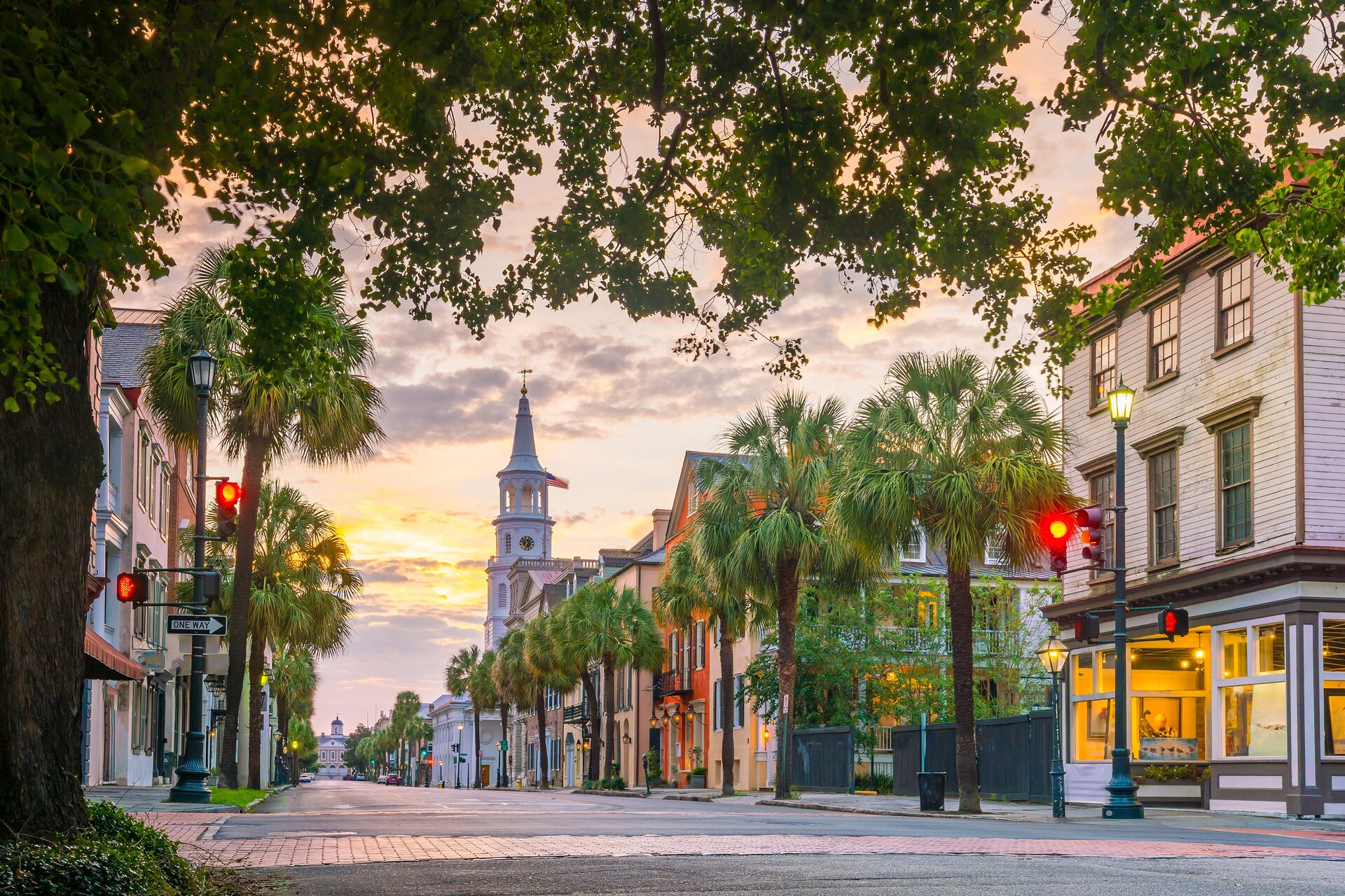 Downtown Charleston's historic streets with bright houses on Rainbow Row and palm trees lining the sidewalk