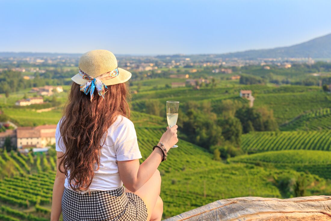 Intrepid traveller tasting fresh sparkling Prosecco at the source