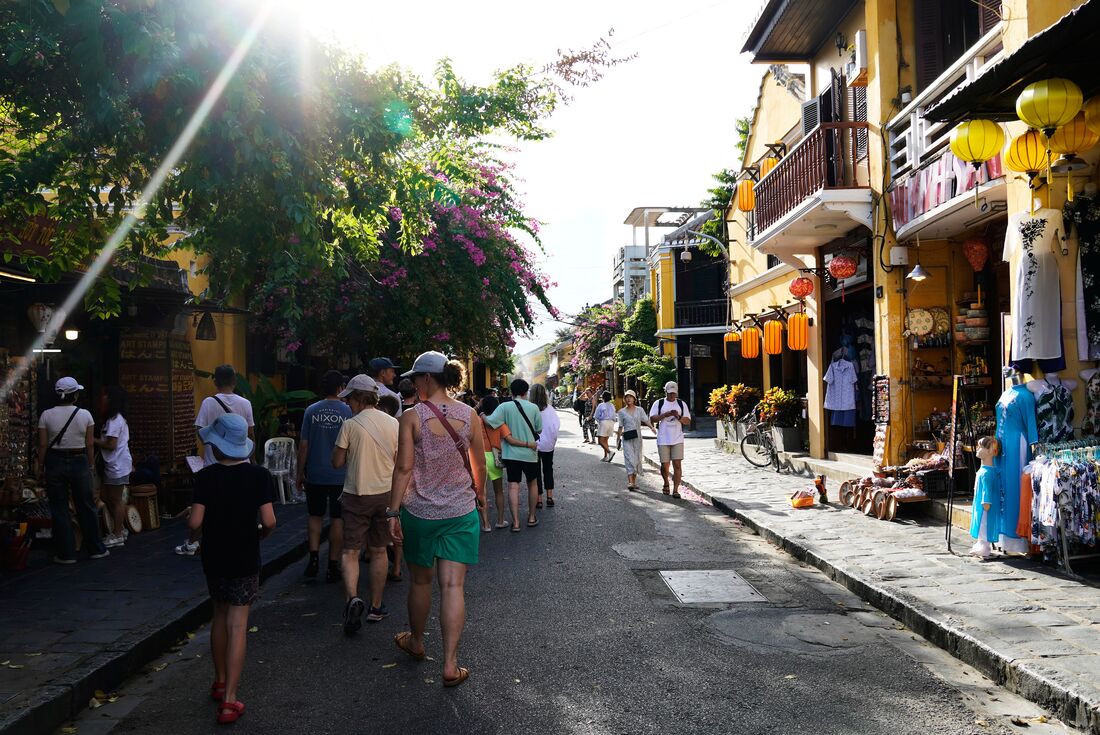Group of family travellers walking through the street markets in Hoi An, Vietnam