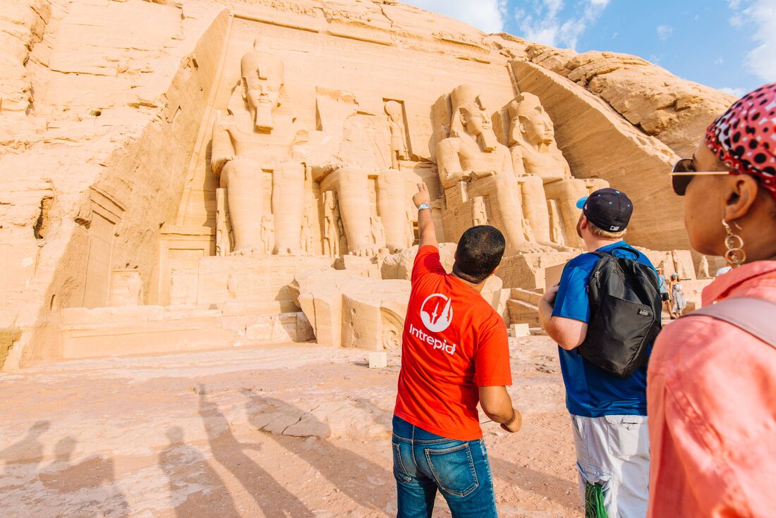 Traveller points out details on the front of Abu Simbel temples in Egypt