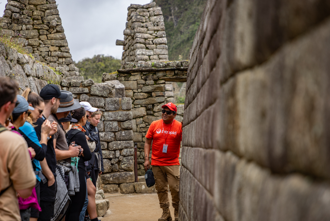 Intrepid leader talking about Machu Picchu with travellers in Peru
