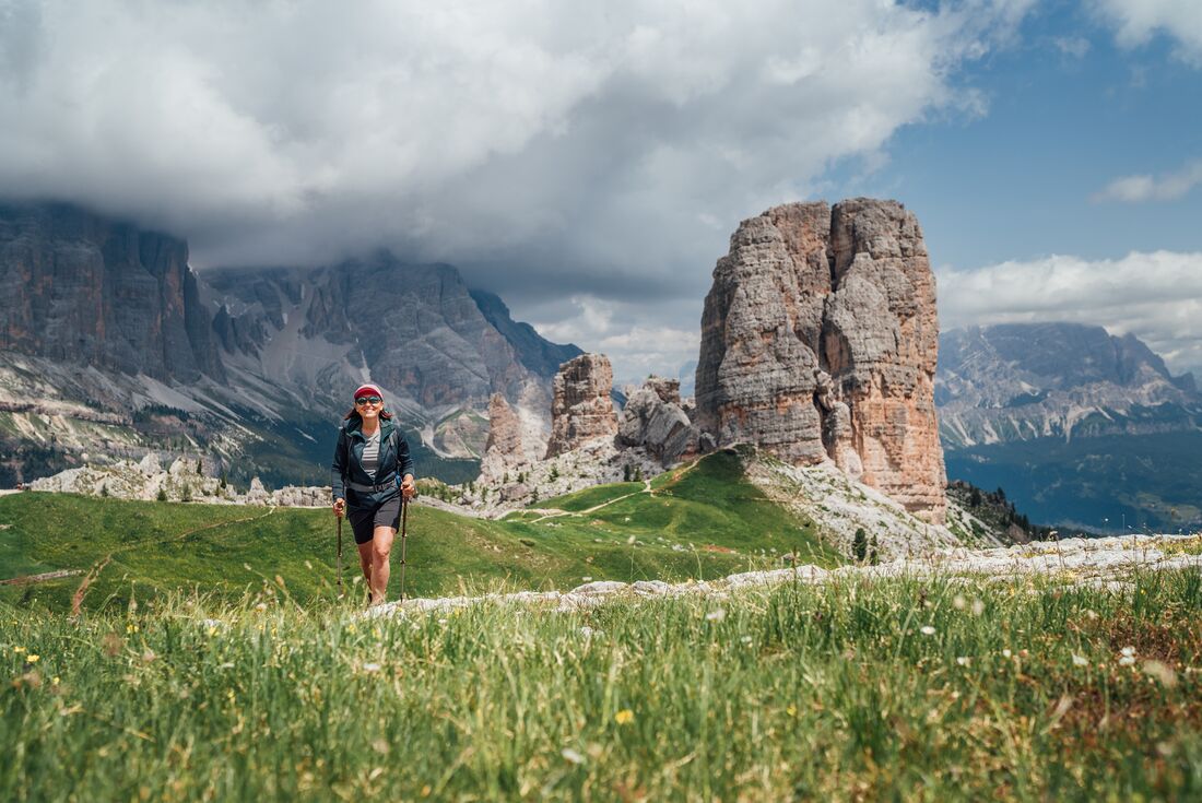 Intrepid traveller crests a hill trekking Cinque Torri near Cortina d'Ampezzo in Italy's Dolomite mountains