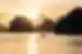 A small fishing boat crosses the waters of Ha Long Bay at sunset