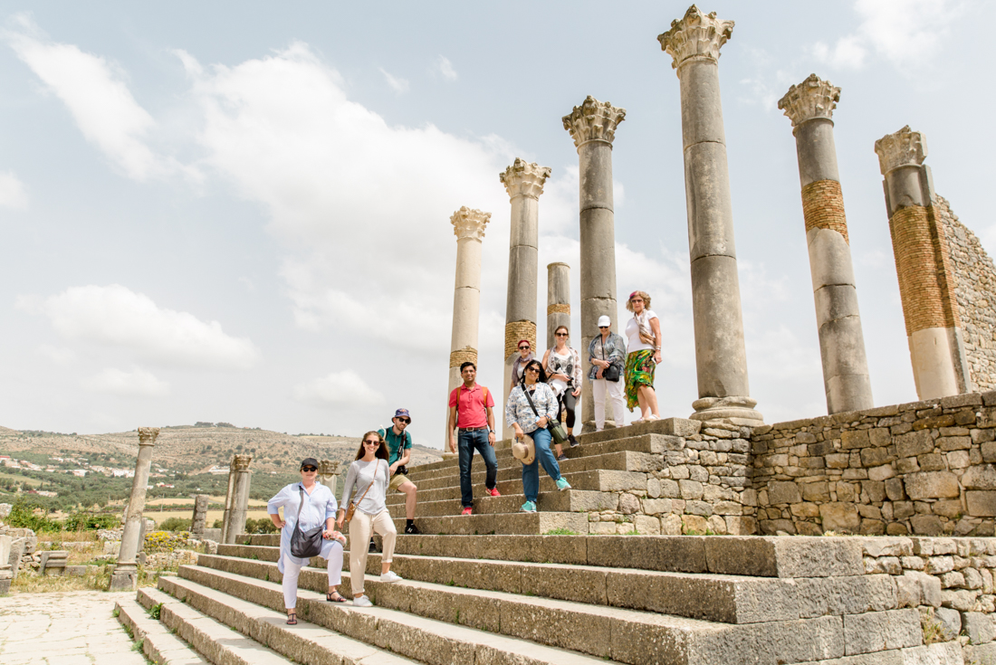 Group of Intrepid travellers pose at Volubilis ruins in Morocco