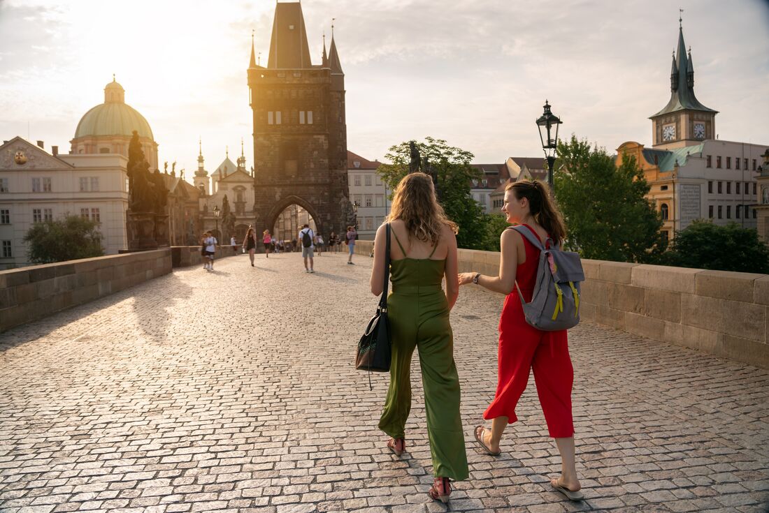 Intrepid travellers in comfortable summer wear explore Prague's Old Town on the Charles Bridge in Czechia