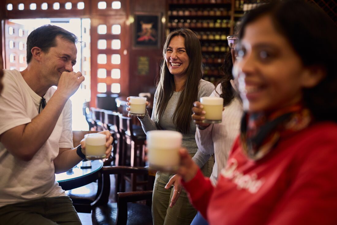 Intrepid travellers and leader enjoy fresh pisco sours in Cusco Peru