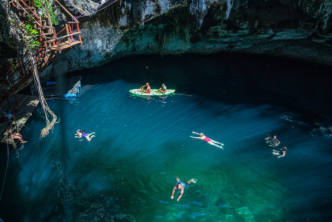 Travellers swimming in hate Cenotes, Mexico