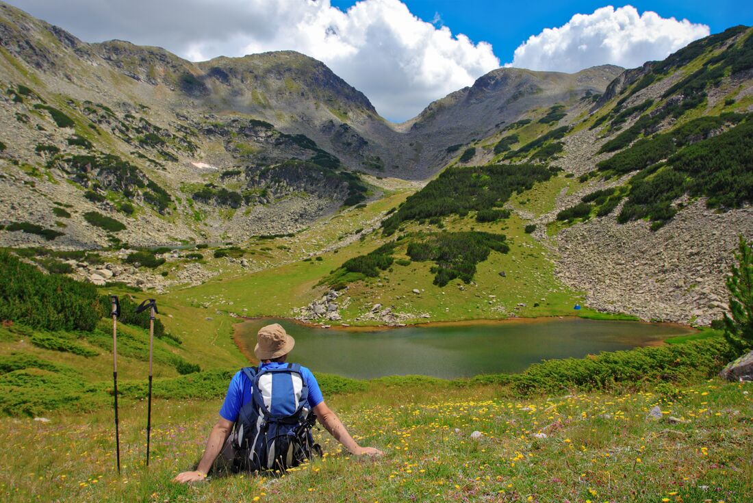 Traveller takes a break at Prevalski Lake in Pirin Mountains, Bulgaria