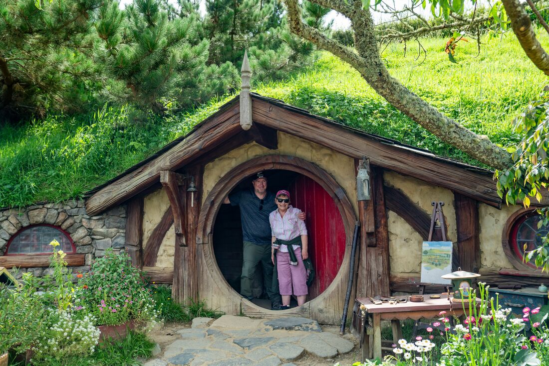 Two travellers take a photo on the Hobbiton movie set, New Zealand