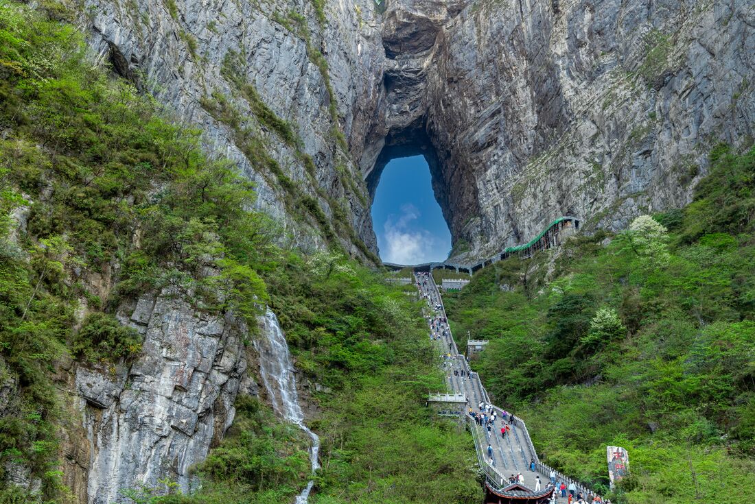 Travellers walk long stairs to step into the sky through Tianmen Cave, Heaven's Gate in Hunan, China