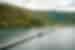 Wide view of bridge crossing the water to Yenbuba Village and mountainous forest background in Indonesia