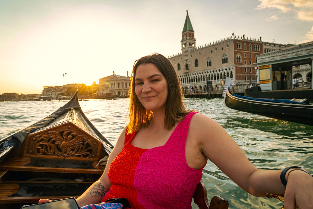 Traveller enjoys a gondola ride during sunset in Venice, Italy