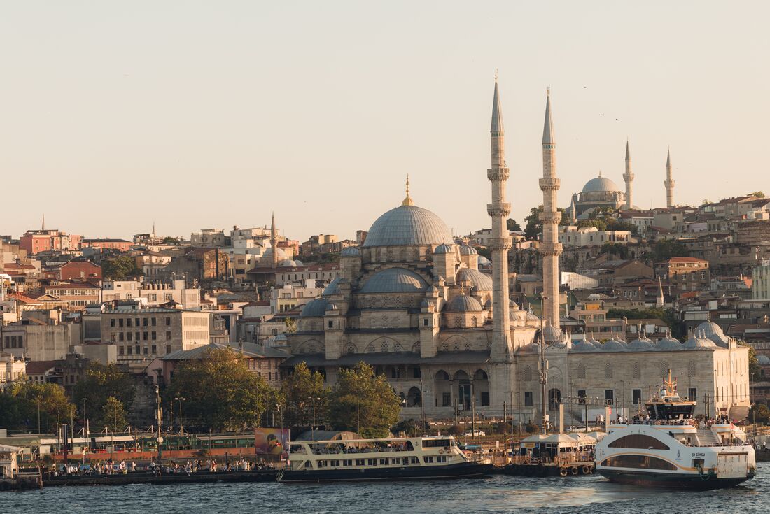 View of mosque and surrounding city along the river with boats in Istanbul, Turkey