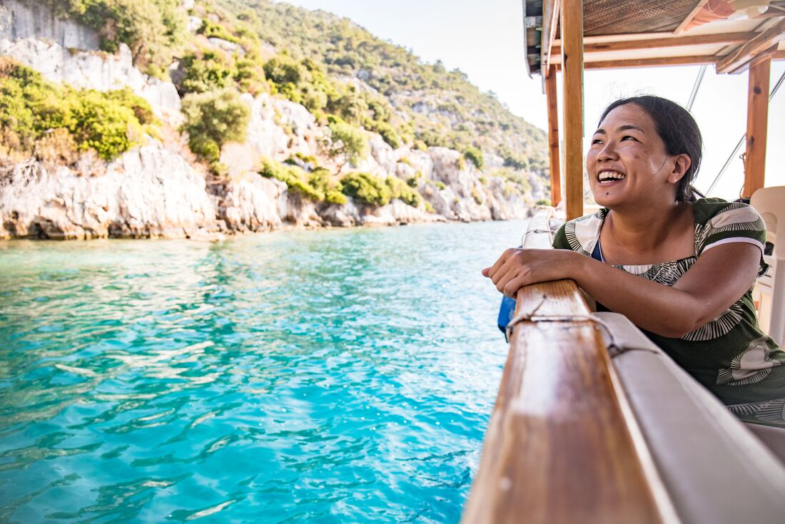 Intrepid traveller looks out at the scenery while relaxing on a boat ride in Kas, Turkey