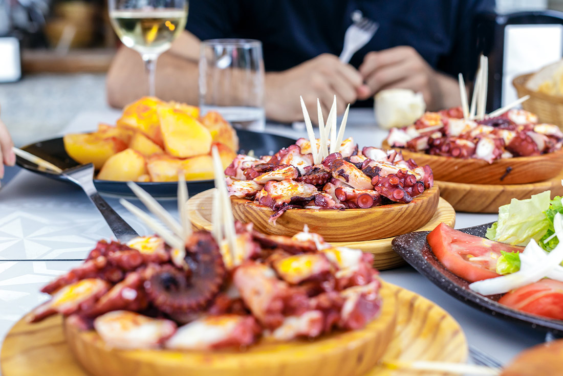 Group lunch enjoying fresh octopus, also known as Pulpo